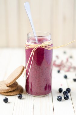 Cranberry and black currant smoothie in glass jars with cookies 