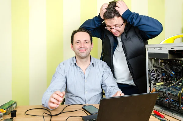 Happy computer engineer repairing broken computer while  male cu — Stock Photo, Image