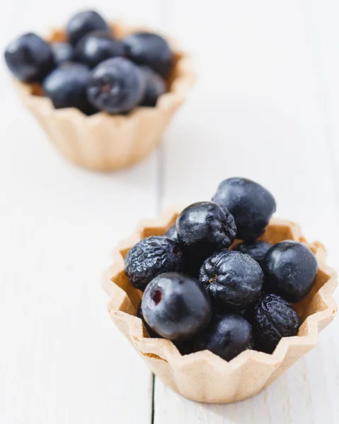 Chokeberry fruit cup cake on a light wooden boards. Top View