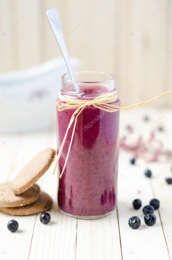 Cranberry and black currant smoothie in glass jars with cookies 