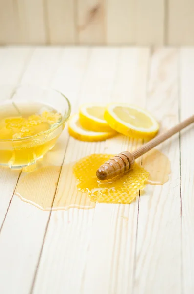 Honey dipper in honey with honeycomb — Stok fotoğraf