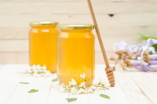 Dois frascos de mel de gafanhoto com flores de gafanhoto — Fotografia de Stock