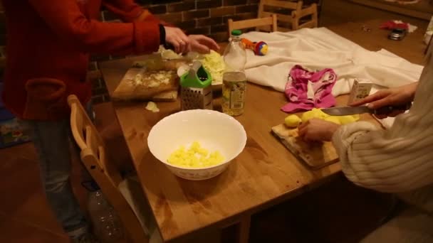 Девушки режут капусту и картошку на кухне — стоковое видео