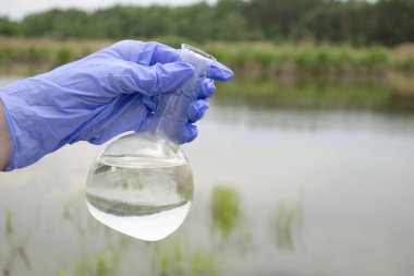 Gölden, nehirden bir örnek. Kalite göstergeleri için laboratuvar asistanı tarafından su örnekleme.