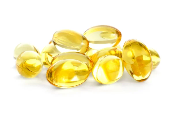 Beyaz arka planda balık yağı kapsülleri izole edilmiş. Beyaz arka planda izole edilmiş sarı balık yağı kapsülleri yığını. Omega-3 balık yağı kapsülleri. Sarı balık yağı kapsüllerine yakın çekim.