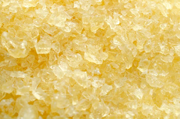 Gelatin, yellow powder top view. Background, texture of crystals of gelatin, close-up. Dry gelatin texture, top view. Dry yellow gelatin powder, top view. Pile of isinglass, top view.