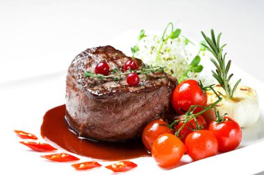 Beyaz arka planda izole edilmiş kiraz domatesli biftek.