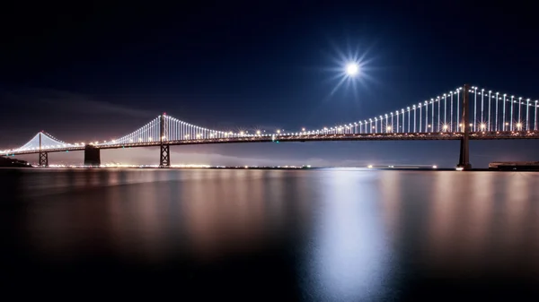 Суперлуние над мостом через залив — стоковое фото