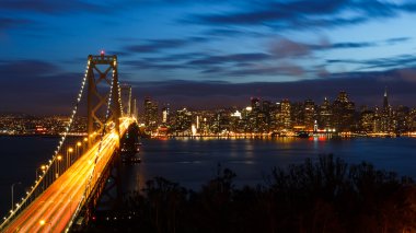 San Francisco Bay Bridge and skyline at night clipart