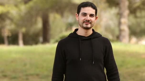 Joven sosteniendo la forma del corazón en el parque — Vídeo de stock