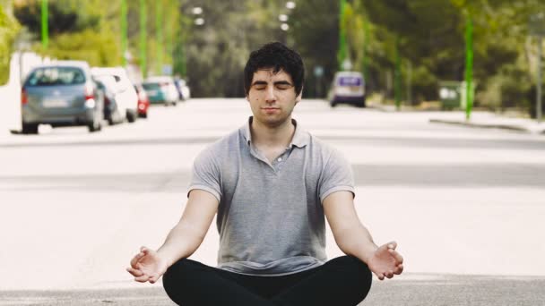 Молодой человек медитирует посреди улицы, для памятования концепции — стоковое видео