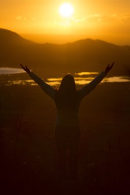 Sunrise için bekleyen Kollarını açarak genç kadın