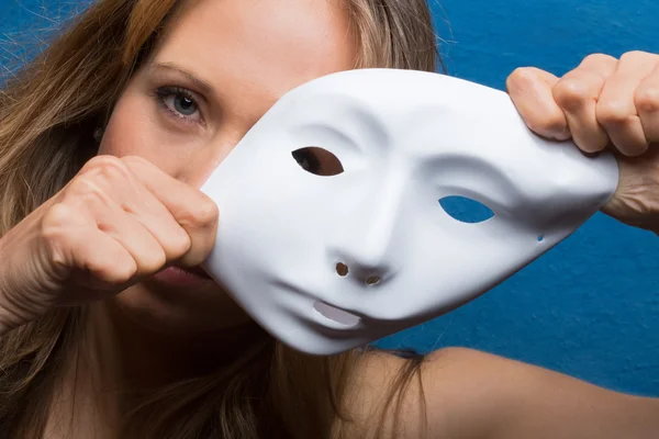 Boos vrouwelijke gezicht halve bedekt met witte masker — Stockfoto