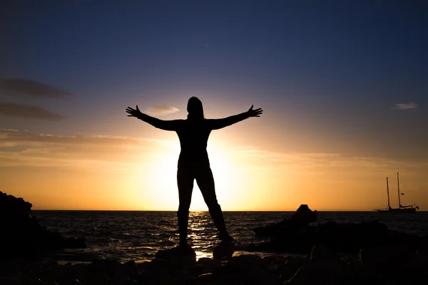 Silhouette de femme mature à bras ouverts regardant vers la mer — Photo