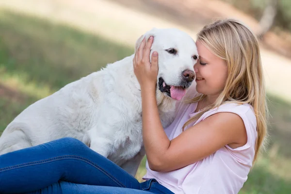 Blondýna teenager se starým senior labrador pes v parku — Stock fotografie
