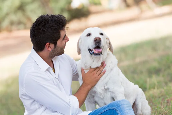 Mladý muž se starým senior pes labrador — Stock fotografie