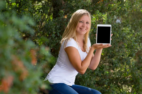 屋外デジタル タブレットを示す金髪の若い女性 — ストック写真