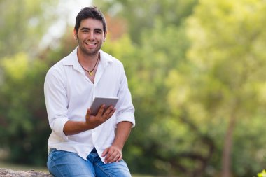 Internet açık parkta kullanan genç adam