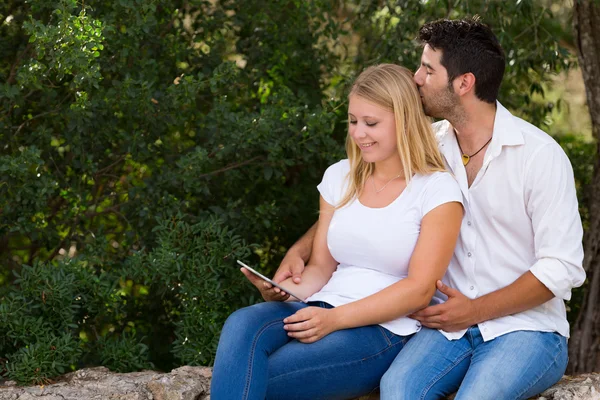 Jovem casal navegar na web ao ar livre com tablet digital — Fotografia de Stock