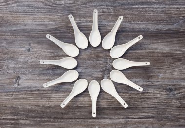 bir çiçek için düzenlenmiş yapay ahşap masa üzerinde on iki kaşık