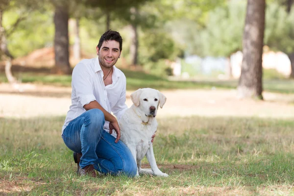 Latin yakışıklı ile eski üst düzey labrador köpek — Stok fotoğraf