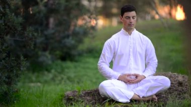 Genç adam doğada meditasyon