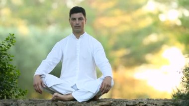 Latin delikanlı duvarda oturan ve meditasyon