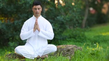 Sakin genç adam açık havada meditasyon yapıyor