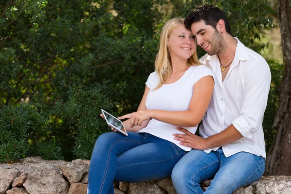 Casal adolescente usando tablet digital ao ar livre — Fotografia de Stock