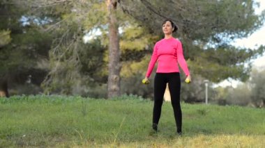 parkta ağırlıkları ile beyaz kadın fitness yaparken egzersiz