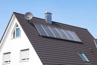 Kırmızı çatıdaki güneş paneli