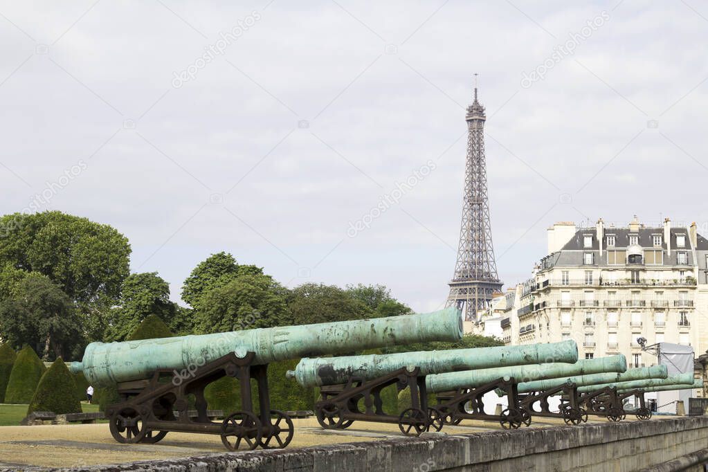 The war cannons at the entrance of the Invalides building and the Eiffel tower in the background