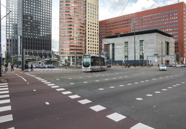 ROTTERDAM, NETHERLANDS - 9 Mayıs 19: Rotterdam 'da yoğun trafik caddesi, tramvay, bisiklet ve insanlar, Erasmus Köprüsü yakınlarındaki modern mimari