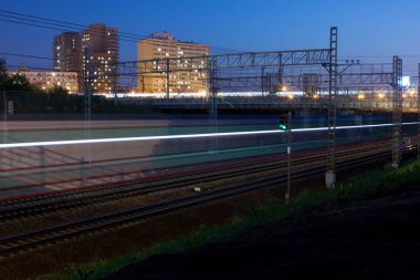 Elektrikli tren arkasında güzel bir far izi bıraktı. Fotoğraf, 2021 yazında Moskova 'nın Butyrsky bölgesinde çekildi. Tren, gökyüzü, trafik..