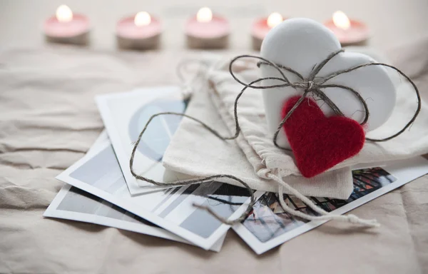 Biscotto allo zenzero bianco a forma di cuore che giace sulle cartoline per San Valentino con candele accese sullo sfondo . — Foto Stock