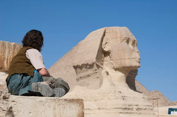 Homem está sentado na frente da famosa Esfinge egípcia em Gizé — Fotografia de Stock