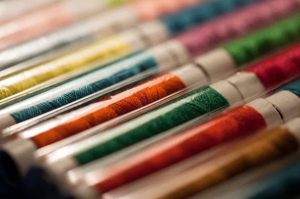 Nahaufnahme von Spulen aus Farbfäden in einer Reihe. — Stockfoto