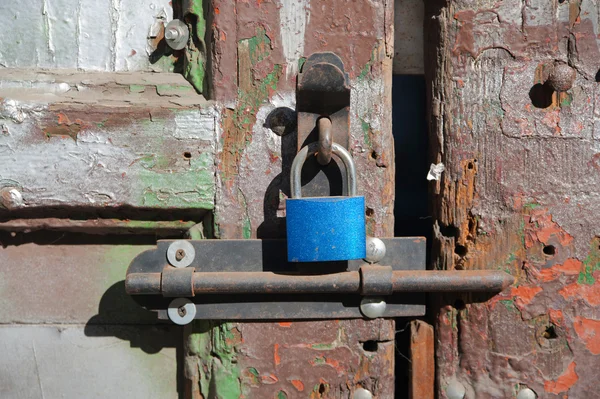 New blue  lock on the old wooden cracked  door — Stock Photo, Image