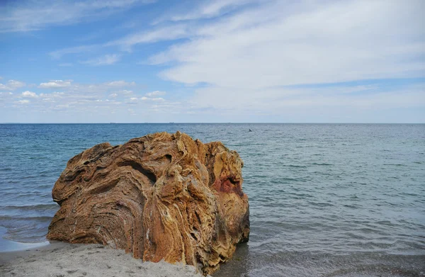 Big colorful stone is rising above sea surface — Stock Photo, Image