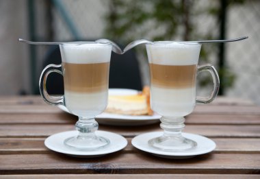 Close-up of two cups of coffee latte on open terrace clipart