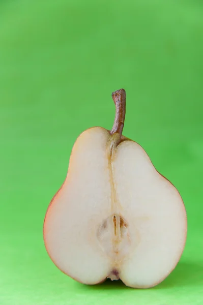 La moitié de la poire mûre sur fond vert . — Photo