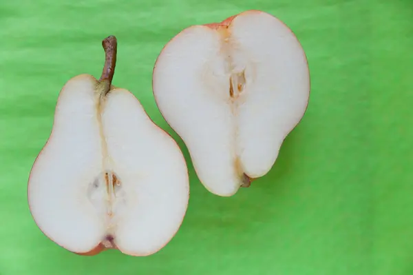 Deux moitiés de la poire mûre sur fond vert — Photo