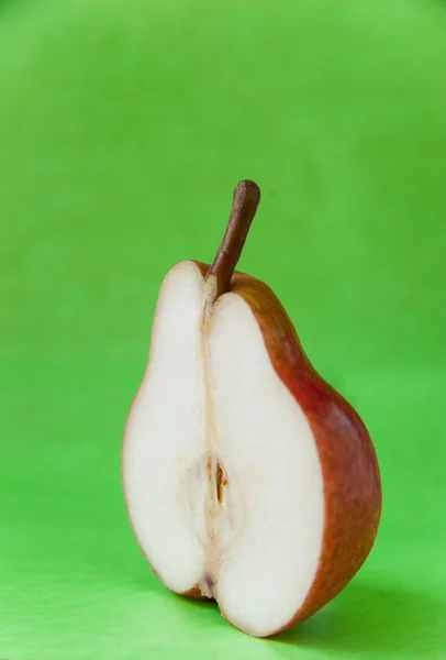 La moitié de la poire mûre sur fond vert . — Photo