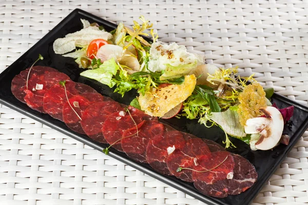 Rindfleisch-Carpaccio mit Parmesan, Kapern und Rucola — Stockfoto