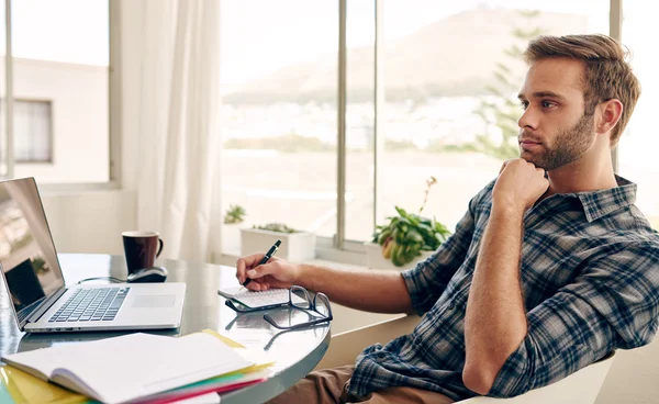 Estudiante pensando mientras está sentado en su escritorio — Foto de Stock