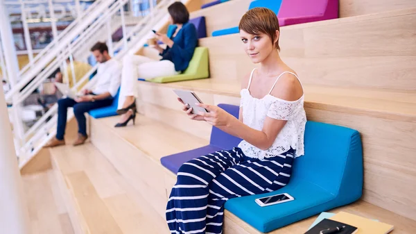 Güzel beyaz kız öğrenci tablet ile kameraya bakıyor