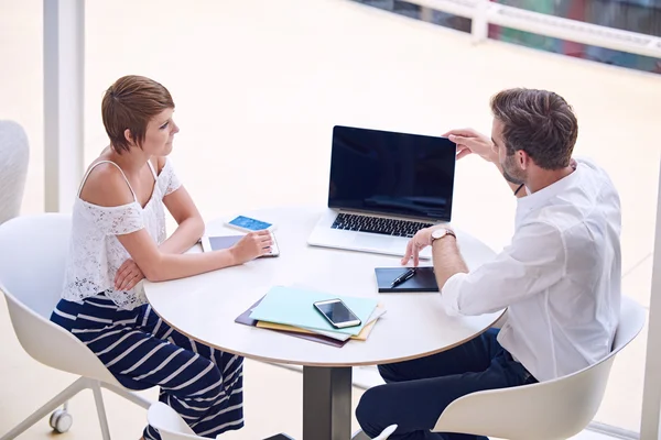 Mann öffnet Laptop, während er mit Frau am Tisch sitzt — Stockfoto