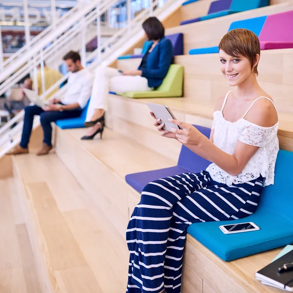 Mujer caucásica bien parecido sonriendo a la cámara con la tableta Imagen De Stock