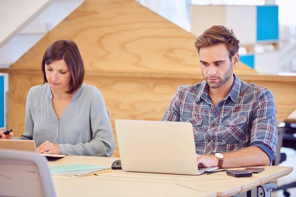 Uomo e donna al lavoro l'uno accanto all'altro — Foto Stock