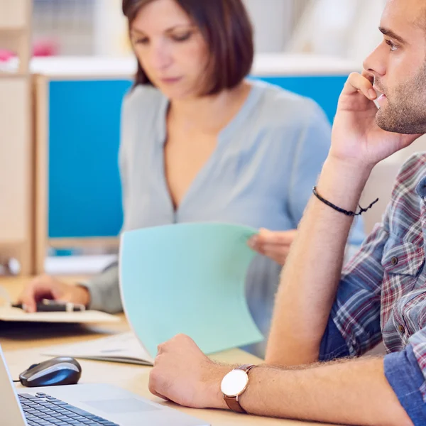 Arka planda çalışan kadın ile telefonda konuşan adam